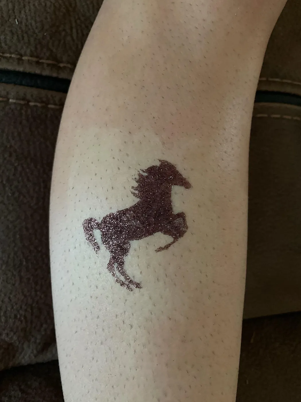 A horse-shaped temporary tattoo on an arm